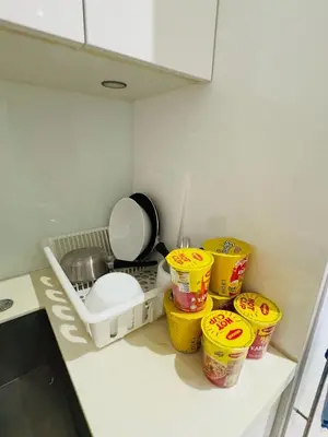 a kitchen counter with yellow baskets and a sink at URBAN COMFY HOME at SkySuites Near KLCC Complimentary Breakfast in Kuala Lumpur