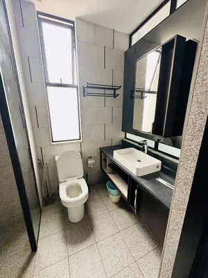 a bathroom with a toilet and a sink and a mirror at Scarletz Suites KLCC by TaheeenS in Kuala Lumpur