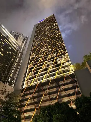 a tall building is lit up at night at Scarletz Suites KLCC by TaheeenS in Kuala Lumpur