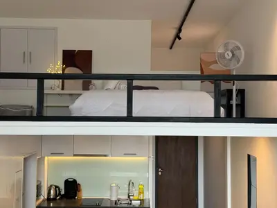 a bedroom and a kitchen with a bed in a room at Cozy Fall Suite at EST Bangsar With Garden Scenery in Kuala Lumpur