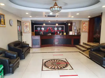 a lobby with a bar with leather chairs and a table at AGE Hotel in Kuala Lumpur