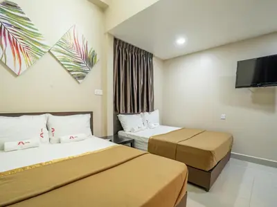 a hotel room with two beds and a flat screen tv at AGE Hotel in Kuala Lumpur