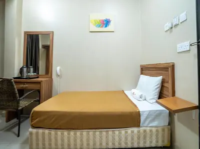 a small bedroom with a bed and a desk at AGE Hotel in Kuala Lumpur
