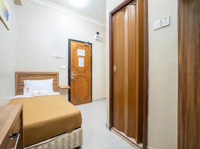 a small room with a bed and a door at AGE Hotel in Kuala Lumpur