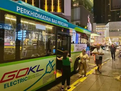 a group of people standing next to a bus at LATEST facing Pavilion main entrance in Kuala Lumpur