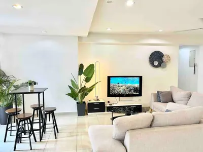 a living room with a couch and a tv on a wall at LATEST facing Pavilion main entrance in Kuala Lumpur