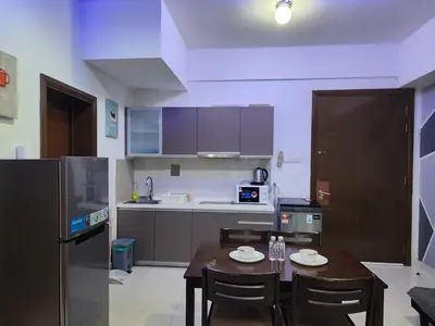 a kitchen with a table and chairs and a kitchen with a refrigerator at Regalia residence KLCC By Glory Homes in Kuala Lumpur