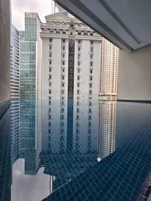 a reflection of a building in a pool of water at Binjai 8 KLCC in Kuala Lumpur