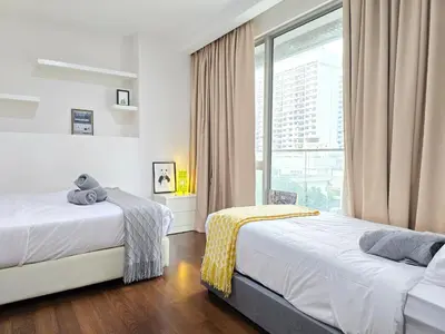 two beds in a room with a window at Bukit Bintang Fairlane Residence #81 Pavilion Kuala Lumpur in Kuala Lumpur