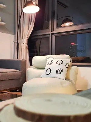 a living room with a white chair and a window at Family Suite M Vertica Sunway Velocity Ikea KL MRT in Kuala Lumpur
