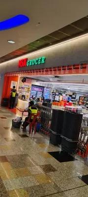 a kiwi grocery store with two people standing in the store at KL Marigold Apartment At Times Square in Kuala Lumpur