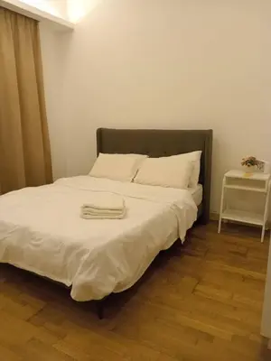 a bedroom with a large bed with white sheets at Luxury Balcony Suites- Homestay in Kuala Lumpur