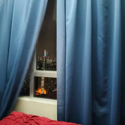 a bedroom with a blue curtain and a window at 2 Rooms Apartment at Kuala Lumpur in Kuala Lumpur