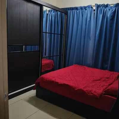 a bedroom with a red bed and blue curtains at 2 Rooms Apartment at Kuala Lumpur in Kuala Lumpur