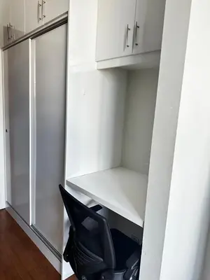 a room with white cabinets and a black chair at KLCC Private Bedroom in DUAL KEY Unit in Kuala Lumpur