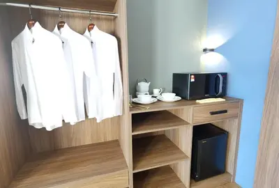 a closet with white clothes hanging on a rack at The Adina - Bangsar Trade Centre in Kuala Lumpur
