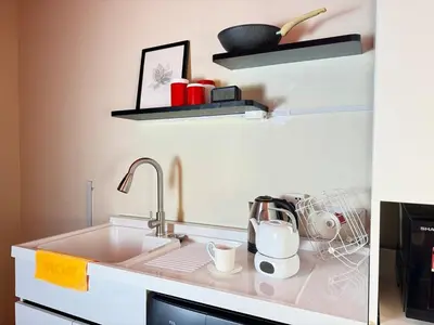 a kitchen counter with a sink and shelves at The Trigo - Bangsar Trade Centre in Kuala Lumpur