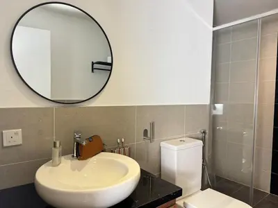 a bathroom with a sink and a mirror and a toilet at The Trigo - Bangsar Trade Centre in Kuala Lumpur