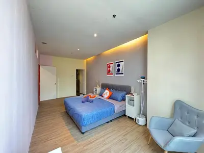 a bedroom with a blue bed and a chair at The Trigo - Bangsar Trade Centre in Kuala Lumpur