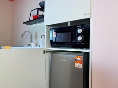 a microwave on top of a refrigerator in a kitchen at The Trigo - Bangsar Trade Centre in Kuala Lumpur