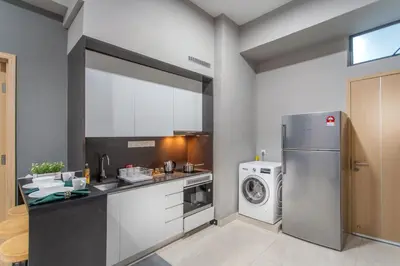 a kitchen with a refrigerator and a washing machine at The Colony & Luxe Kuala Lumpur with Skypool by Cobnb in Kuala Lumpur