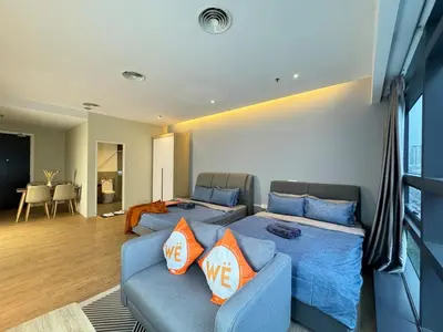 a living room with a blue couch with orange pillows at The Benton - Bangsar Trade Centre in Kuala Lumpur