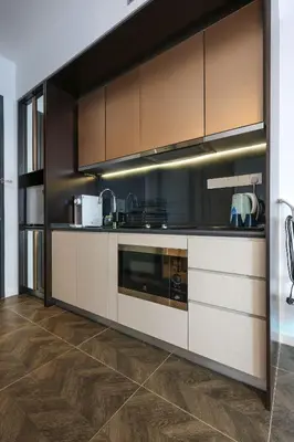 a kitchen with brown and white cabinets and wooden floors at \u5409\u9686\u5761Scarletz\u65af\u5609\u4e3d \u53cc\u5b50\u5854\u9644\u8fd1 \u65e0\u8fb9\u6cf3\u6c60 \u914d\u5065\u8eab\u623f \u5de5\u4f5c\u5ba4 in Kuala Lumpur