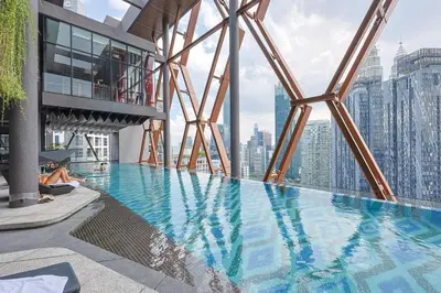 a woman laying on the edge of a swimming pool on a building at \u5409\u9686\u5761Scarletz\u65af\u5609\u4e3d \u53cc\u5b50\u5854\u9644\u8fd1 \u65e0\u8fb9\u6cf3\u6c60 \u914d\u5065\u8eab\u623f \u5de5\u4f5c\u5ba4 in Kuala Lumpur