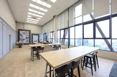 a classroom with tables and chairs and large windows at \u5409\u9686\u5761Scarletz\u65af\u5609\u4e3d \u53cc\u5b50\u5854\u9644\u8fd1 \u65e0\u8fb9\u6cf3\u6c60 \u914d\u5065\u8eab\u623f \u5de5\u4f5c\u5ba4 in Kuala Lumpur