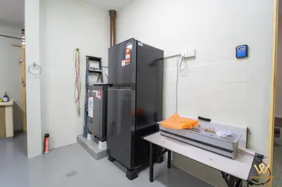 a kitchen with a table and a large refrigerator at Gather & Stay 5BR Cozy Home near Setapak & Wangsa Maju in Kuala Lumpur