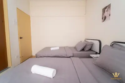 a small bedroom with two beds and a door at Gather & Stay 5BR Cozy Home near Setapak & Wangsa Maju in Kuala Lumpur
