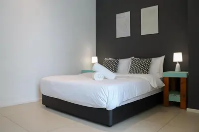 a bedroom with a large bed with a black headboard at Arcoris Mont Kiara FaceHome in Kuala Lumpur