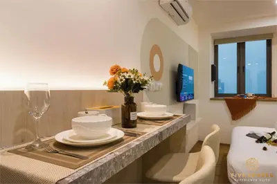 a room with a table with plates and flowers on it at Riveria Signature Suites, KL Sentral in Kuala Lumpur