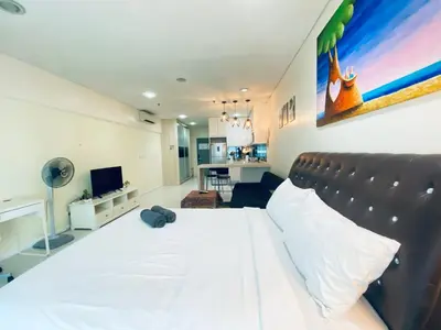 a bedroom with a large white bed and a living room at Summer Suites KLCC by EASY STAY in Kuala Lumpur