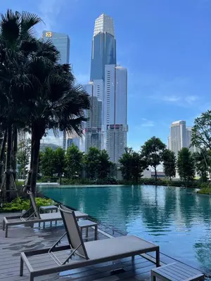 a swimming pool with lounge chairs and a city skyline at Agile Bukit Bintang in Kuala Lumpur