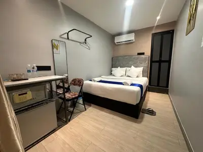 a small room with a bed and a desk and a kitchen at SS Grey inn Bukit Bintang in Kuala Lumpur