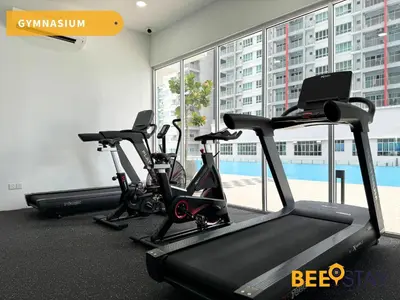 a gym with two treadmills and two exercise bikes at Salak Selatan Pool View with Wifi & Netflix 4PAX in Kuala Lumpur