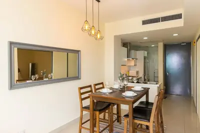 a dining room with a table and chairs and a mirror at Publika Mont Kiara City View Suite - 8KM to KLCC in Kuala Lumpur