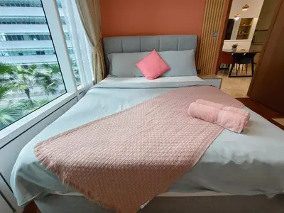 a bed with two pink pillows and a window at Sky suites KLCC by Kuala Lumpur Family Room Stay in Kuala Lumpur