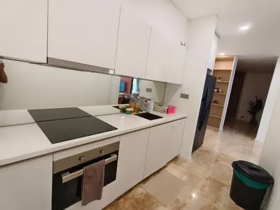 a kitchen with white cabinets and a black refrigerator at Sky suites KLCC by Kuala Lumpur Family Room Stay in Kuala Lumpur