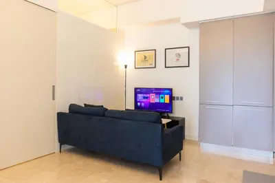 a living room with a blue couch and a tv at The Signature Residence at Sri Hartamas - 2 pax in Kuala Lumpur