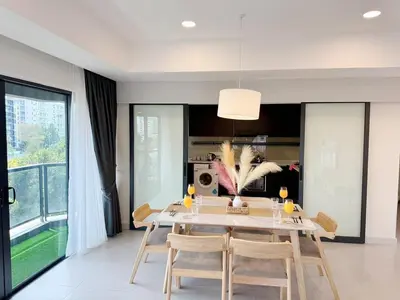 a dining room with a white table and chairs at The Atrium at Jalan Ampang by OKBnB - Spacious Modern 3Bedroom Family Suite 3 mins to KLCC in Kuala Lumpur