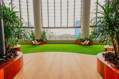 a large room with plants and chairs in a building at The Atrium at Jalan Ampang by OKBnB - Spacious Modern 3Bedroom Family Suite 3 mins to KLCC in Kuala Lumpur