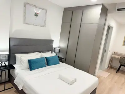 a bedroom with a large bed with blue and white pillows at The Atrium Ampang by OKBnB - Family Suite 3-Minute Access to the Heart of KL in Kuala Lumpur