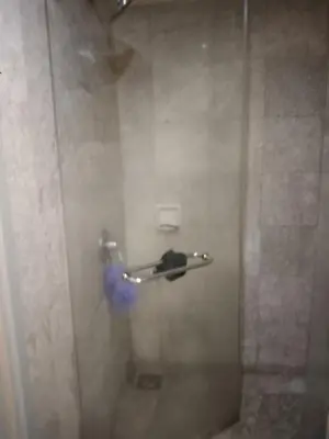 a shower in a bathroom with a blue fire extinguisher at KL hotel time square in Kuala Lumpur
