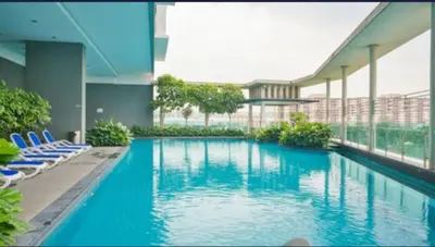 a large swimming pool in a building with blue chairs at 0111 Sweet Home-Casa Residency 2R 2B City View in Kuala Lumpur