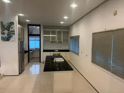 a kitchen with white walls and a black counter top at Bungalow Perkasa in Kuala Lumpur