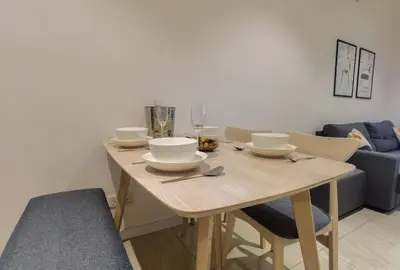 a wooden table with bowls and plates on it at Quill Luxe Stay - KLCC in Kuala Lumpur