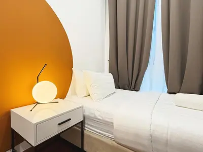 a bedroom with a bed and a table with a lamp at Royce Residences KLCC by WSD in Kuala Lumpur