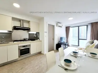 a kitchen and living room with a table and chairs at Bukit Bintang Fairlane Residence #18 Kuala Lumpur in Kuala Lumpur